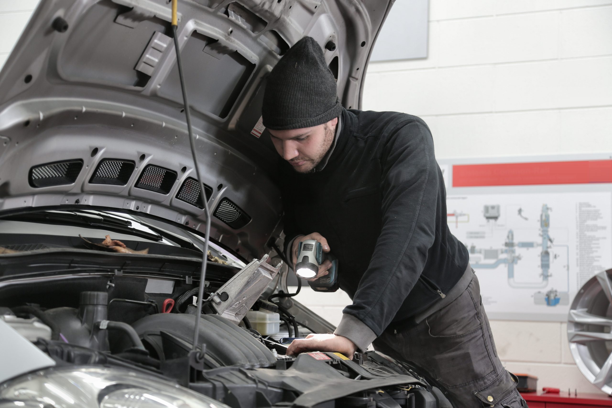 Service technician working under the hood of a vehicle